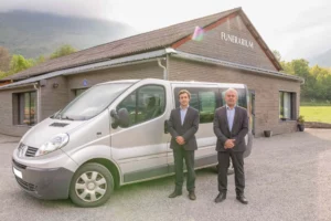 Agents funéraires devant le véhicule de transport et le funérarium