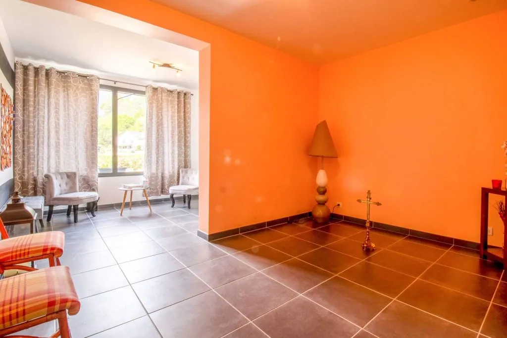 Salon de recueillement lumineux avec croix et fauteuils en chambre funéraire