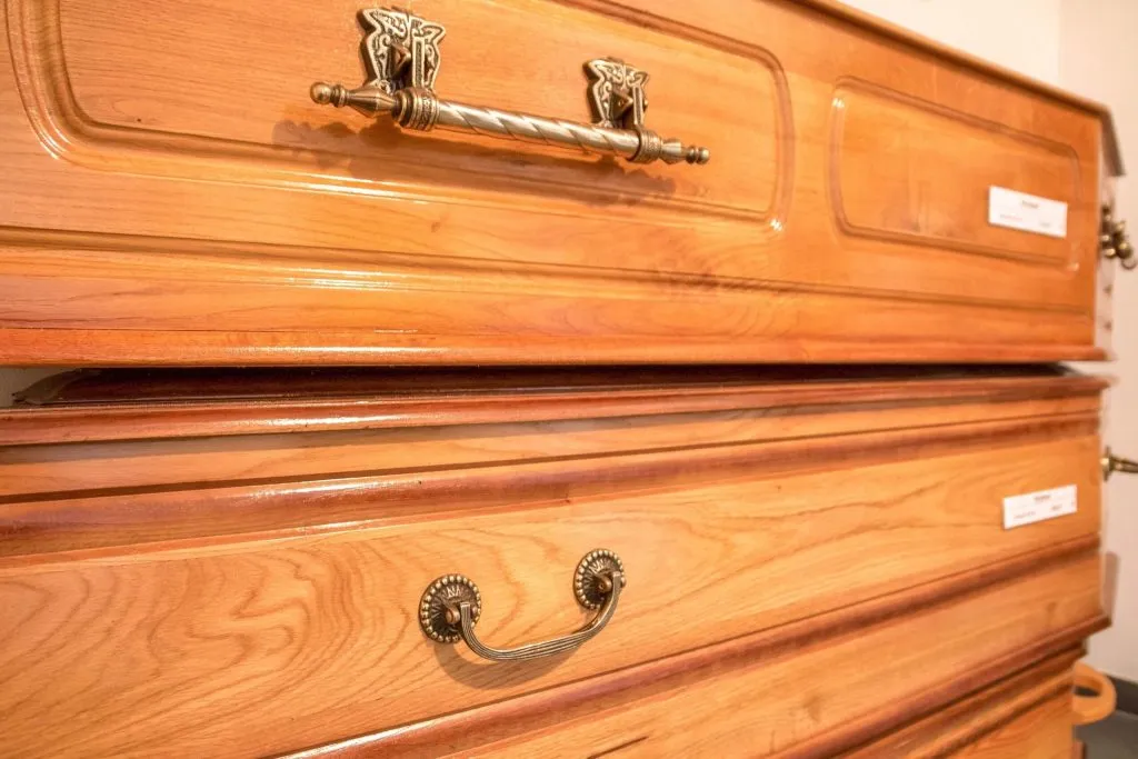 Détail des finitions et de la poignée en bronze d'un cercueil en bois massif